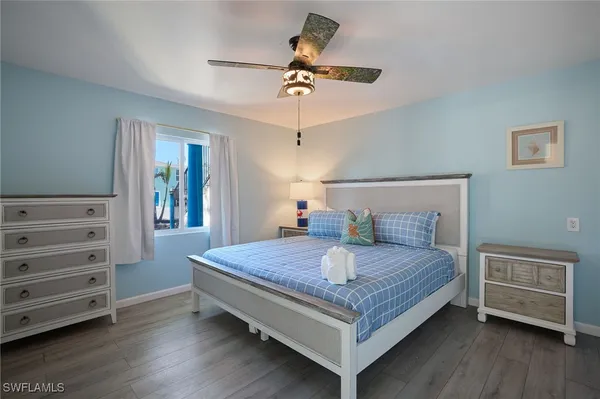 a bedroom with a bed a dresser and a chandelier