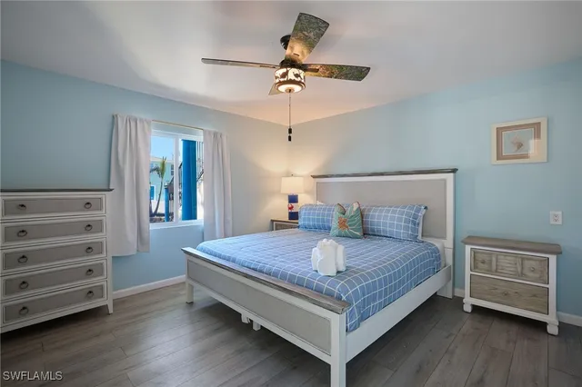 a bedroom with a bed a dresser and a chandelier