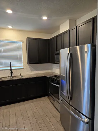 a kitchen with granite countertop a refrigerator and a sink