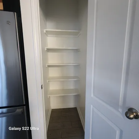 a view of walk in closet with empty racks