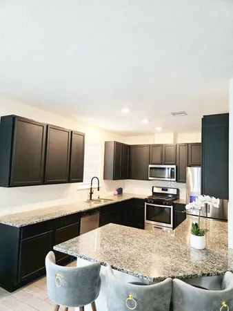 a kitchen with kitchen island granite countertop a sink and a stove
