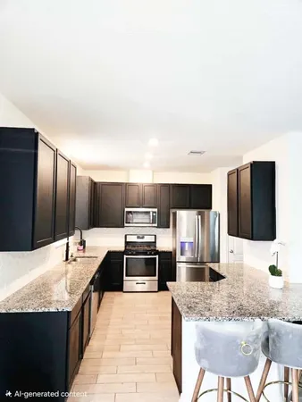 a large kitchen with granite countertop a sink and cabinets
