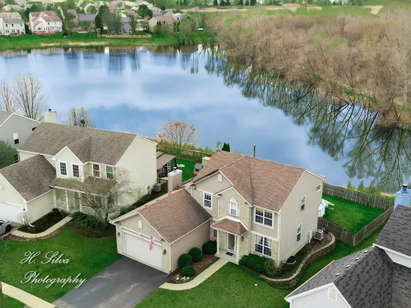 a view of a house with a yard and a pond