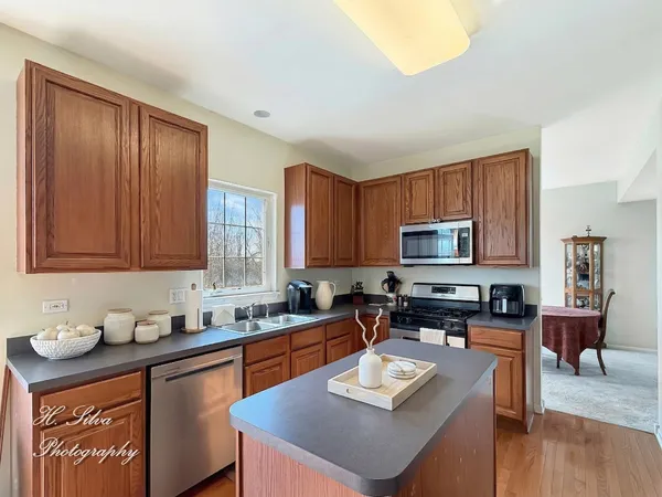 a kitchen with stainless steel appliances granite countertop a sink a stove counter space and cabinets