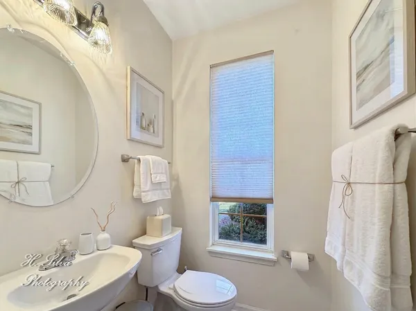 a bathroom with a toilet sink a mirror a vanity and shower