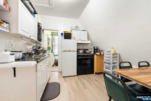 a kitchen with granite countertop white cabinets and white appliances