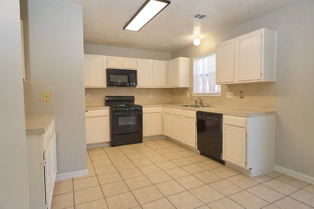 a kitchen with a sink a stove and cabinets