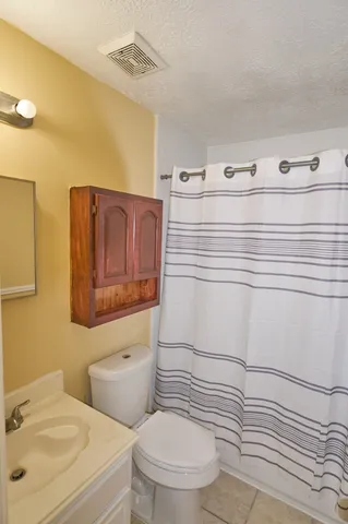 a bathroom with a sink a toilet and mirror