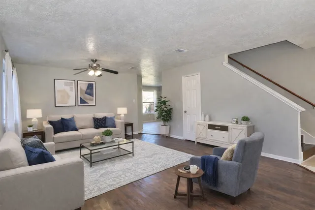 a living room with furniture and wooden floor