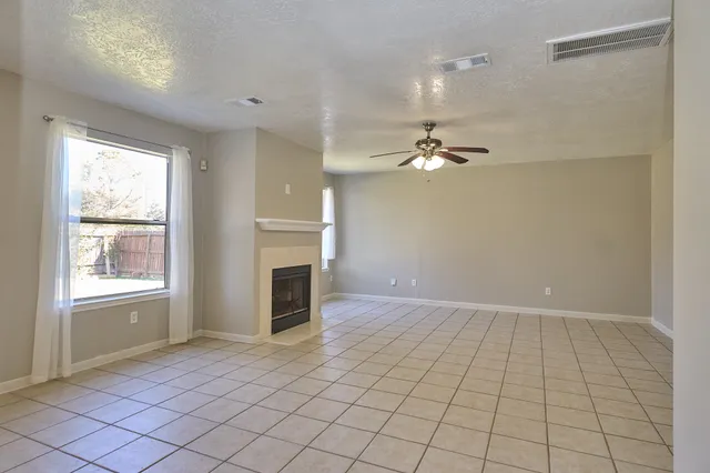 an empty room with fireplace and windows