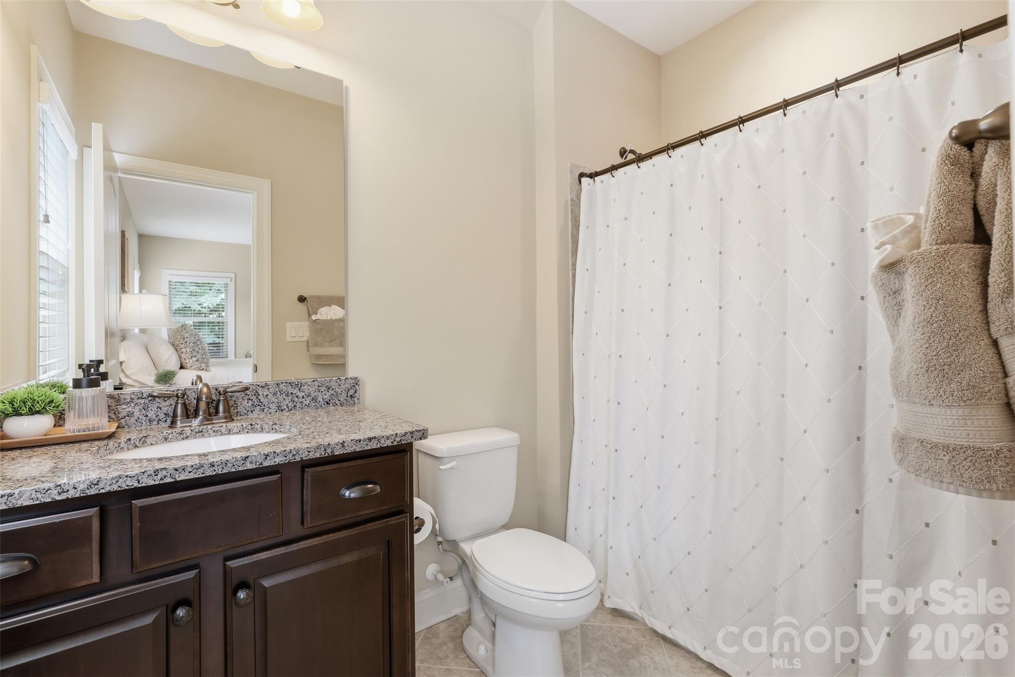 8094 Clems Branch Road Indian Land, SC 29707 - Photo 25 of 38 a bathroom with a granite countertop sink toilet and a mirror