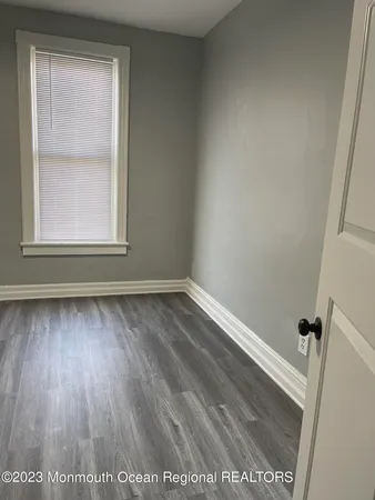 a view of a small space with wooden floor and a window