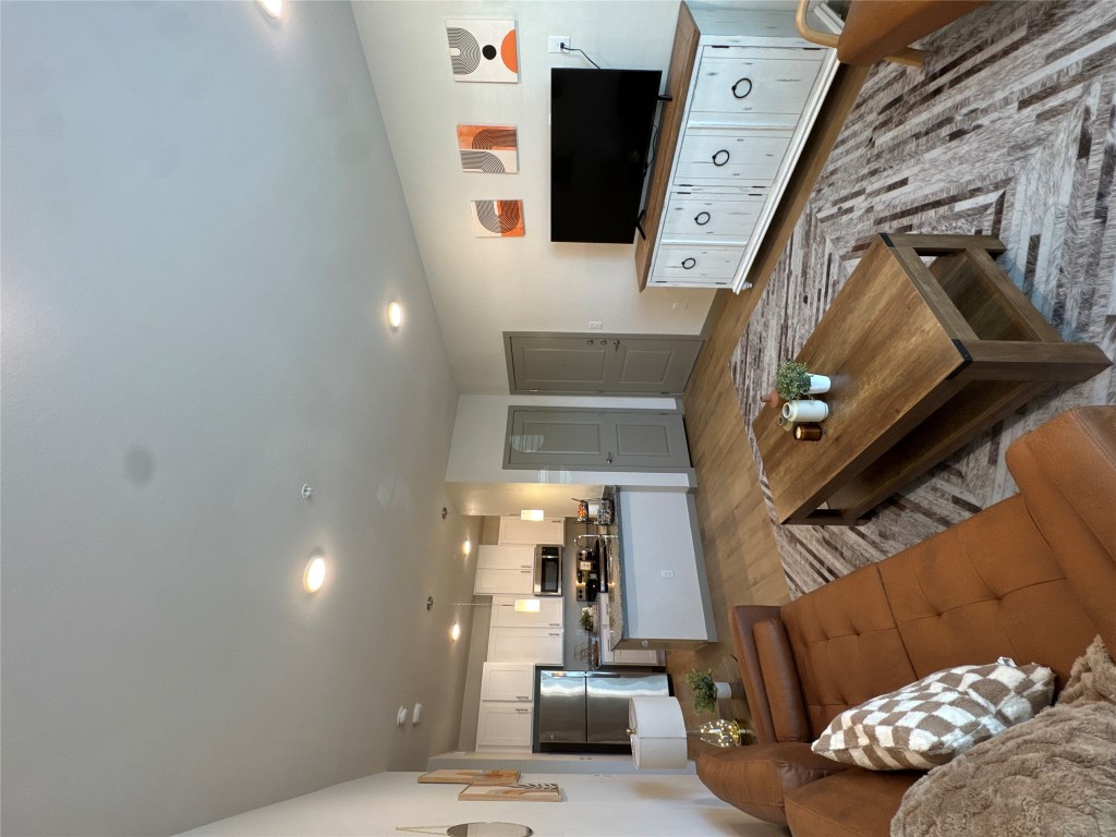 Staged. Living room with wood finished floors and recessed lighting