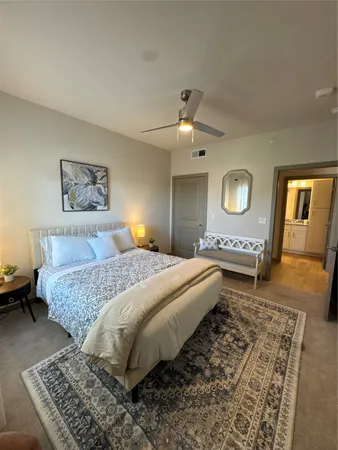 a spacious bedroom with a bed and dresser