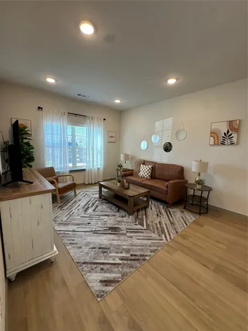 a living room with furniture and a wooden floor