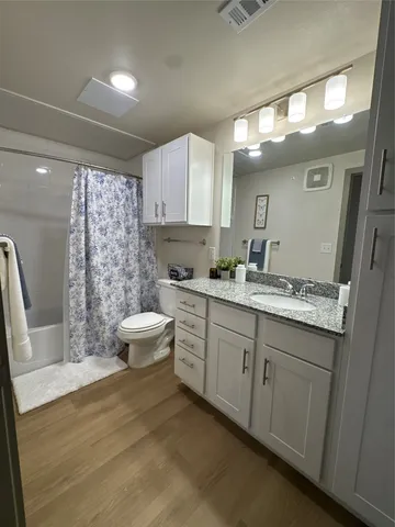 a bathroom with a double vanity sink toilet and shower
