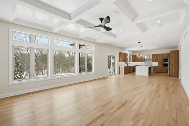 a view of an empty room with a kitchen and a window