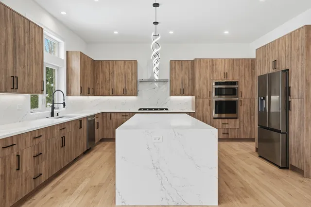 a kitchen with stainless steel appliances a refrigerator sink and wooden cabinets