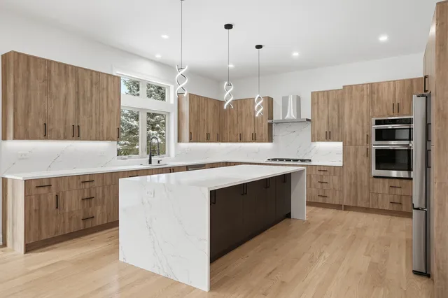 a kitchen with kitchen island granite countertop a sink stove and cabinets