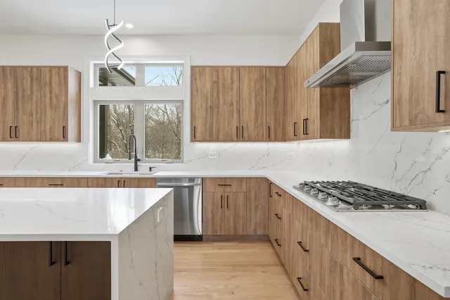 a kitchen with stainless steel appliances granite countertop a refrigerator stove and cabinets