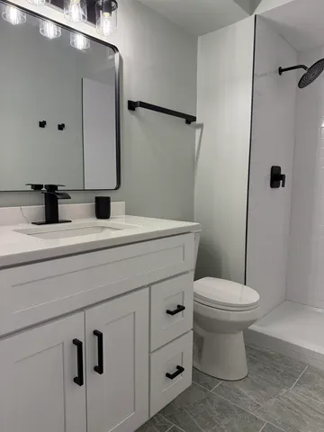 a bathroom with a sink toilet and mirror