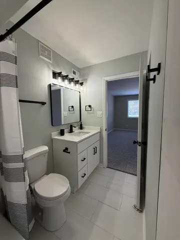 a bathroom with a toilet sink and mirror