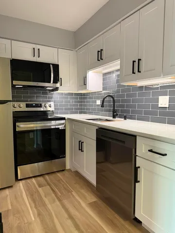 a kitchen with a sink stove and microwave