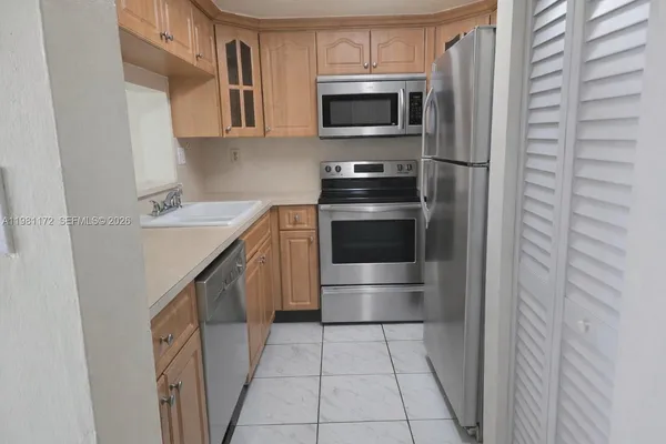 a kitchen with stainless steel appliances a stove microwave and refrigerator