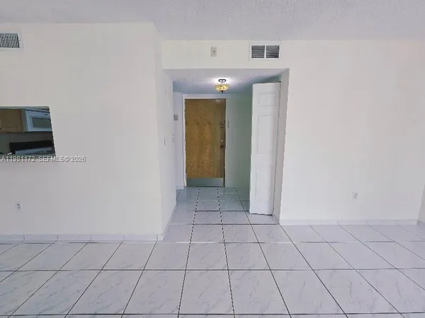 a view of a livingroom with an empty space and a window
