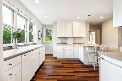 a kitchen with granite countertop white cabinets and white appliances