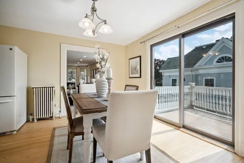 a dining room with furniture a chandelier and wooden floor