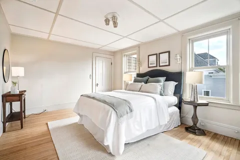 a bedroom with a bed lamp on table and a window