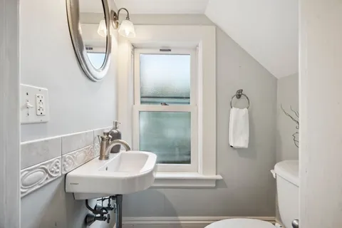 a bathroom with a sink a toilet and a mirror