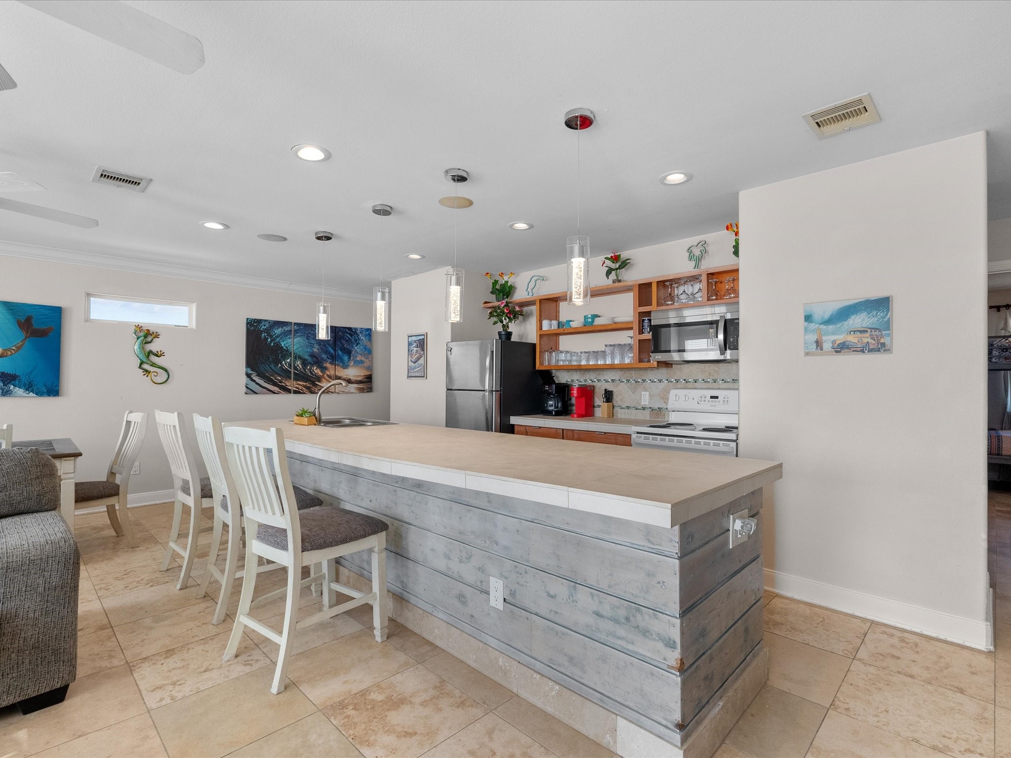 111 Beach Drive Surfside Beach, TX 77541 - Photo 23 of 31 a kitchen with kitchen island a stove a refrigerator and a dining table with wooden floor
