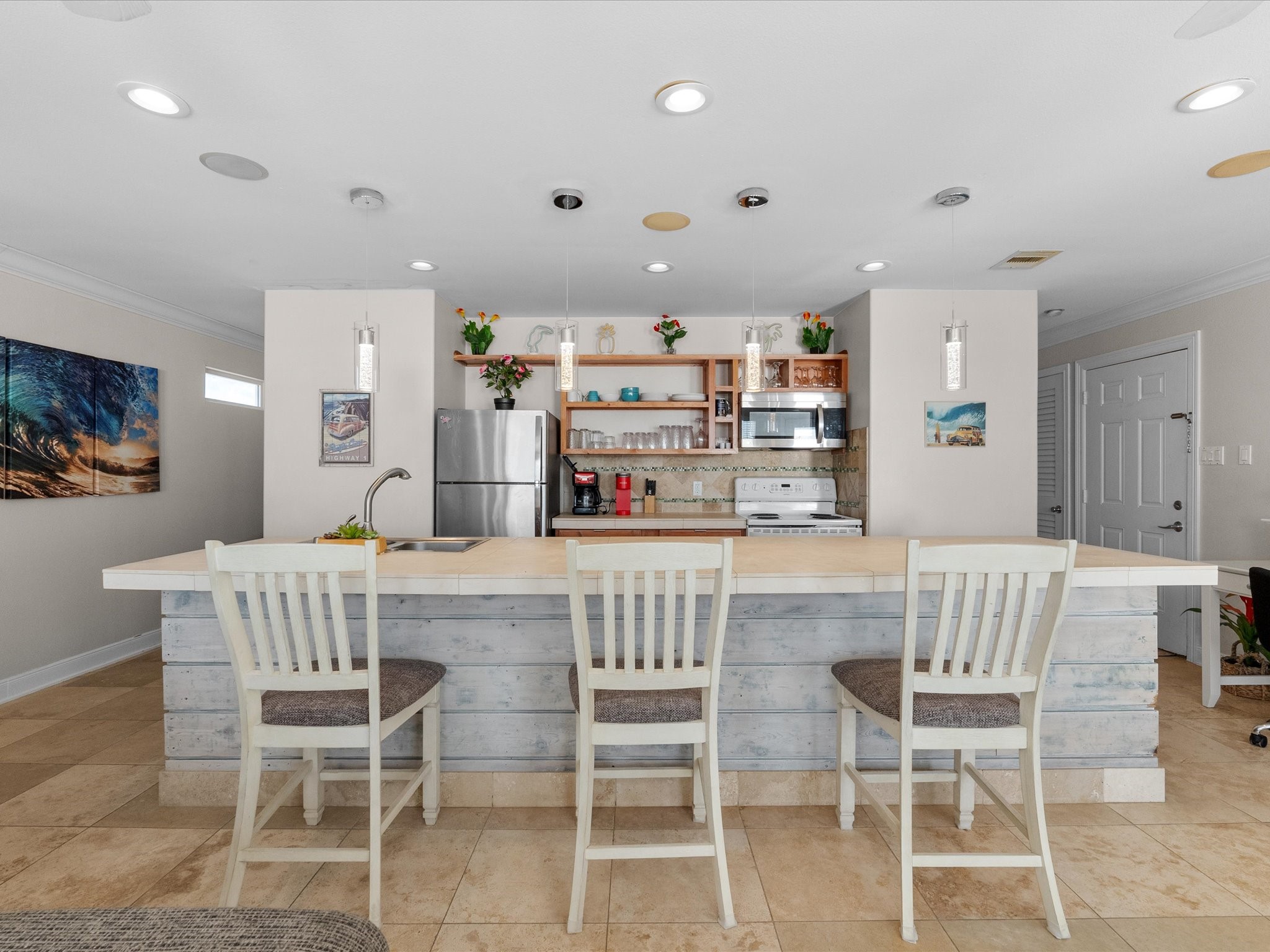 111 Beach Drive Surfside Beach, TX 77541 - Photo 27 of 31 a kitchen with stainless steel appliances kitchen island granite countertop a dining table chairs and a refrigerator