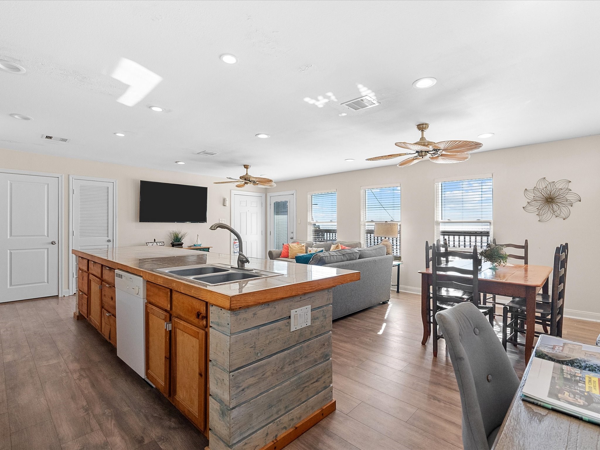 111 Beach Drive Surfside Beach, TX 77541 - Photo 7 of 31 a kitchen with stainless steel appliances granite countertop a stove top oven a sink dishwasher a dining table and chairs with wooden floor