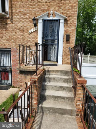 a view of a house with wooden stairs and a table and chairs