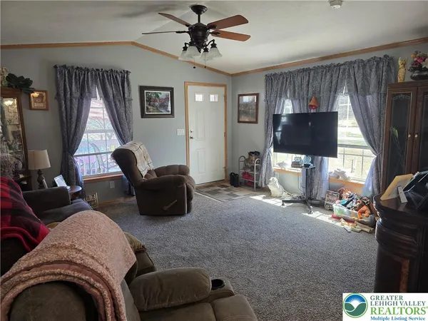 a living room with furniture a flat screen tv and a window