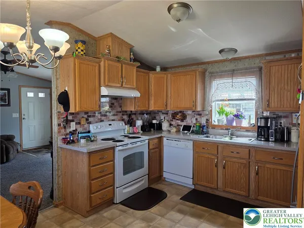 a kitchen with stainless steel appliances granite countertop a sink a stove and cabinets