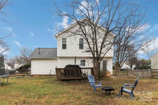 a view of a house with backyard and a tree