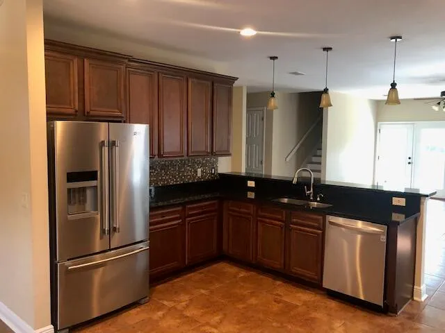 a kitchen with stainless steel appliances granite countertop a stove a sink and a microwave
