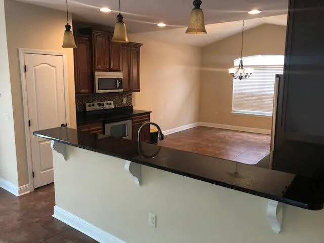 a view of a kitchen with a refrigerator and wooden floor