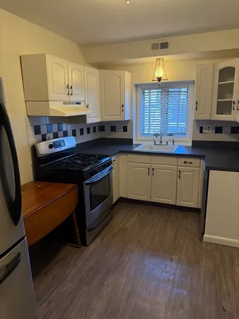 a kitchen with stainless steel appliances granite countertop a stove a sink and a refrigerator