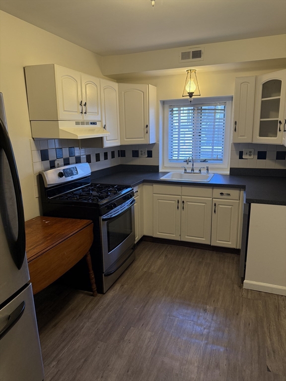 577 Adams Street, Unit D Milton, MA 02186 - Photo 2 of 11 a kitchen with stainless steel appliances granite countertop a stove a sink and a refrigerator