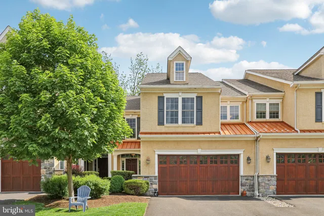 a front view of a house with yard and parking