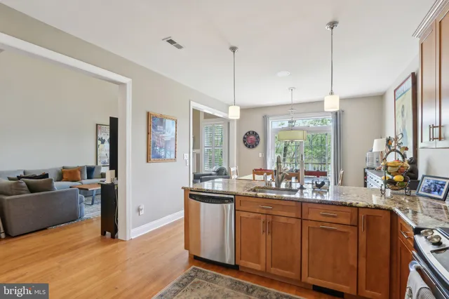 a kitchen with kitchen island granite countertop a sink appliances and cabinets
