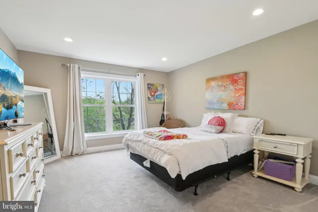 a bedroom with a bed and a large window