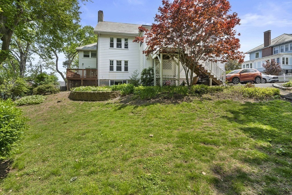 95 Monroe Road, Unit 2R Quincy, MA 02169 - Photo 16 of 19 a view of a white house next to a yard with plants and trees