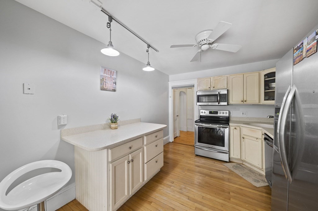 95 Monroe Road, Unit 2R Quincy, MA 02169 - Photo 8 of 19 a kitchen with stainless steel appliances a sink a stove a refrigerator cabinets and wooden floor