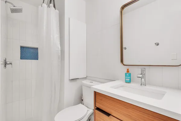 a bathroom with a sink vanity and toilet